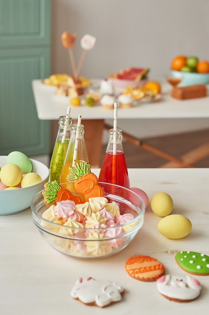 Mesa de cocina con jugo, galletas de Pascua y merengues