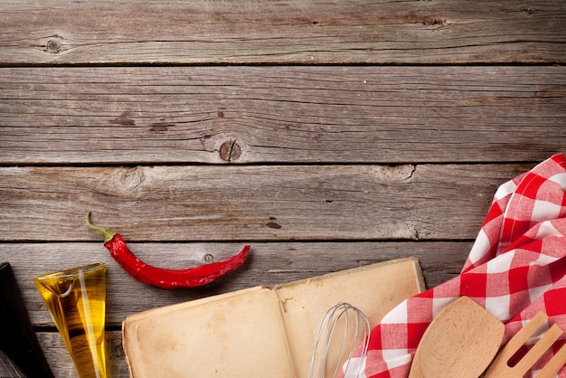 Mesa de cocina con libro de recetas e ingredientes.