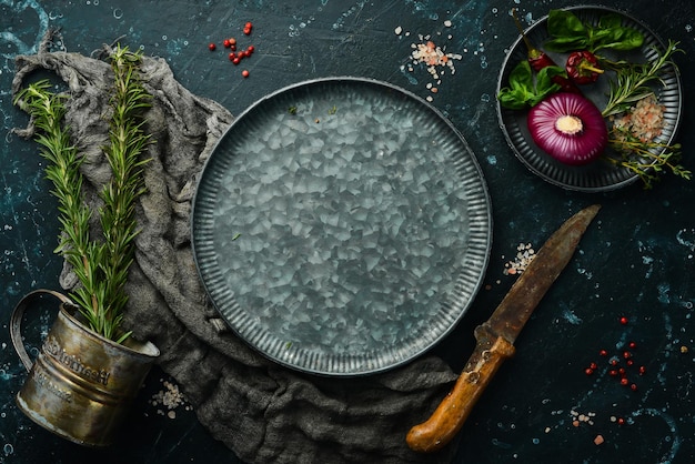 Mesa de cocina oscura con especias y utensilios de cocina Sobre un fondo de piedra negra