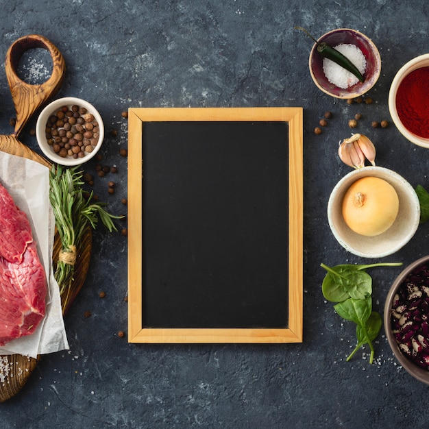 Foto mesa de cocina con pizarra en blanco y carne de res