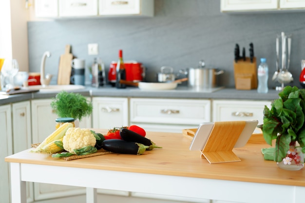 Mesa de cocina con verduras frescas y tableta digital