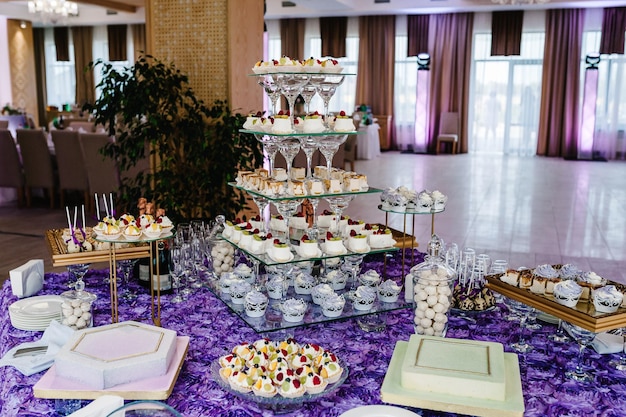 Foto mesa com bolos bolos doces buffet de doces mesa de sobremesa para uma festa guloseimas para a área do banquete de casamento fechar barra de chocolate decorado delicioso