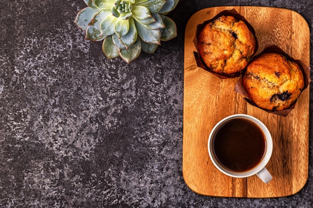 Mesa com bolos, flores e café.