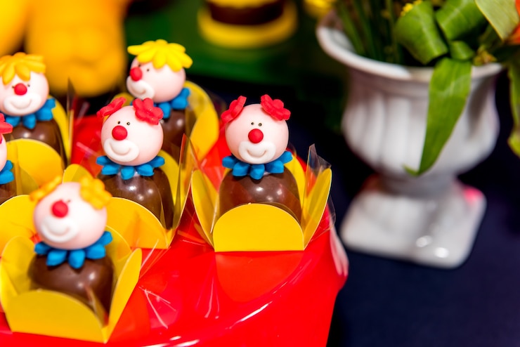 Foto mesa com doces e muffins decorados com cobertura real em festa infantil.