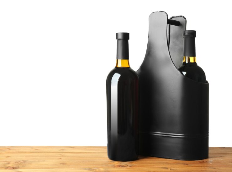 Foto mesa com garrafas de vinho e caixa de presentes em fundo branco