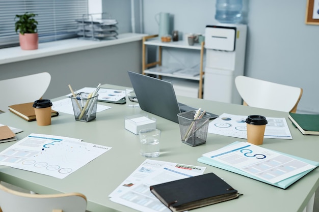 Mesa com laptop de material de escritório e papéis financeiros com dados gráficos