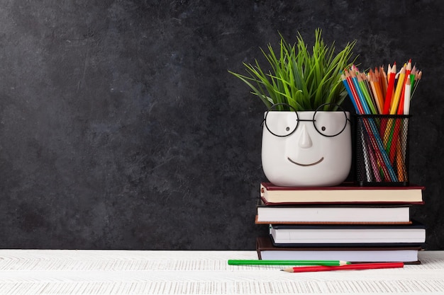 Mesa com livros e planta com óculos