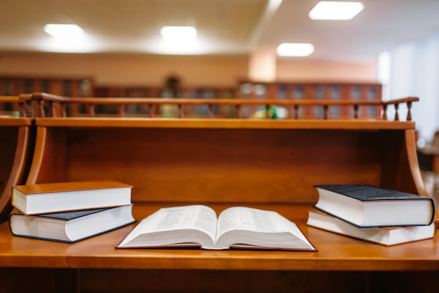 Mesa com livros na sala de leitura, interior da biblioteca da universidade, ninguém. depósito de conhecimento, conceito de educação