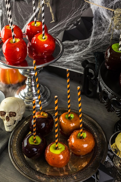 Foto mesa com maçãs doces coloridas para festa de halloween.