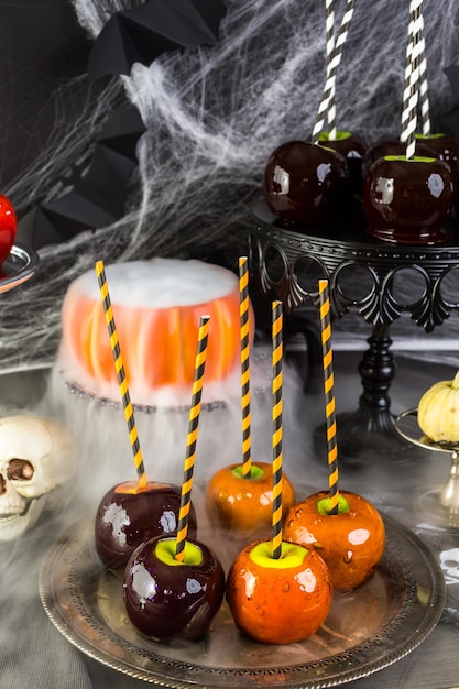 Foto mesa com maçãs doces coloridas para festa de halloween.