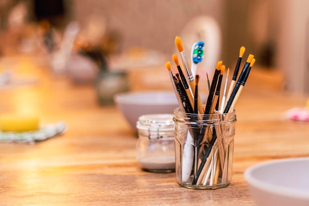 Mesa com pincéis e ferramentas em uma oficina de arte