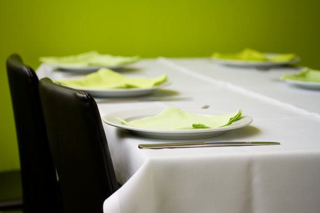 Mesa com pratos e guardanapos verdes