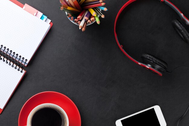 Mesa com smartphone e fones de ouvido do café do bloco de notas