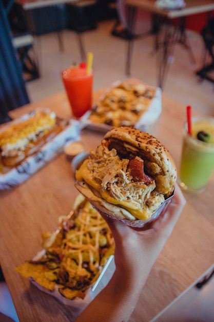 Mesa com sucos cachorro-quente hambúrgueres e nachos