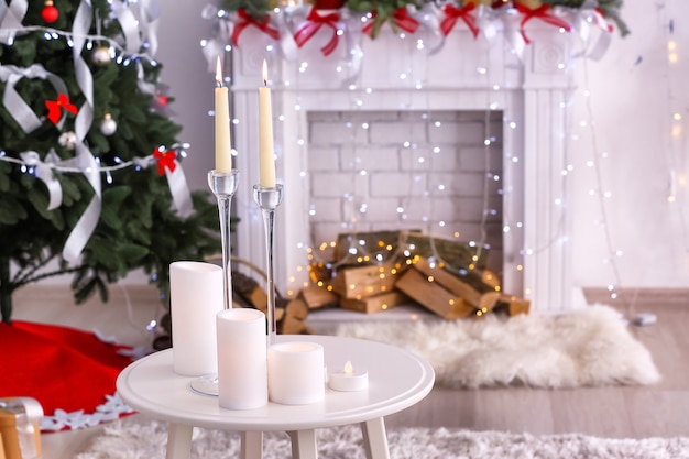 Mesa com velas em sala decorada para o natal