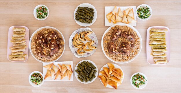 mesa de comedor árabe consiste en rollos de repollo rollos de uva arroz pollo sambousek y qatayef sin personas