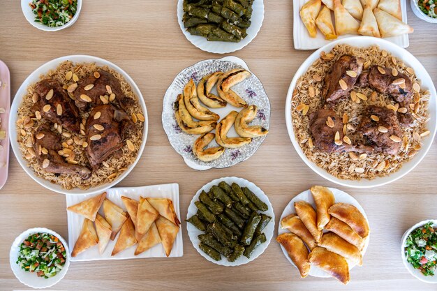 mesa de comedor árabe consiste en rollos de repollo rollos de uva arroz pollo sambousek y qatayef sin personas