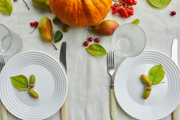 Mesa de comedor con calabaza, bellotas, hojas de peras.