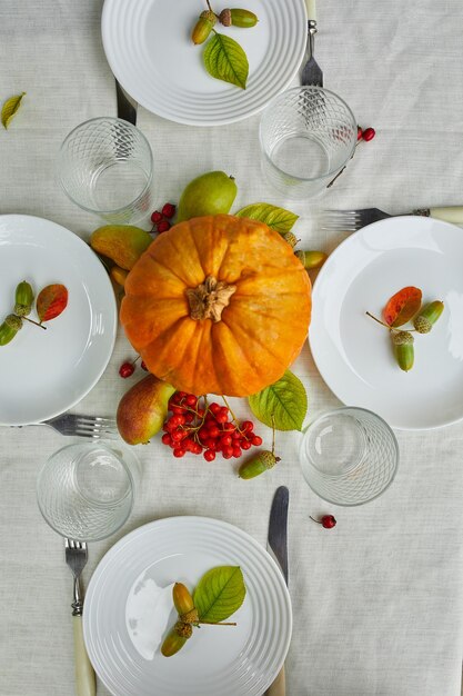 Mesa de comedor con calabaza, bellotas, hojas de peras.