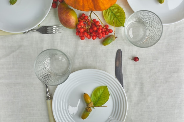 Mesa de comedor con calabaza, bellotas, hojas de peras.