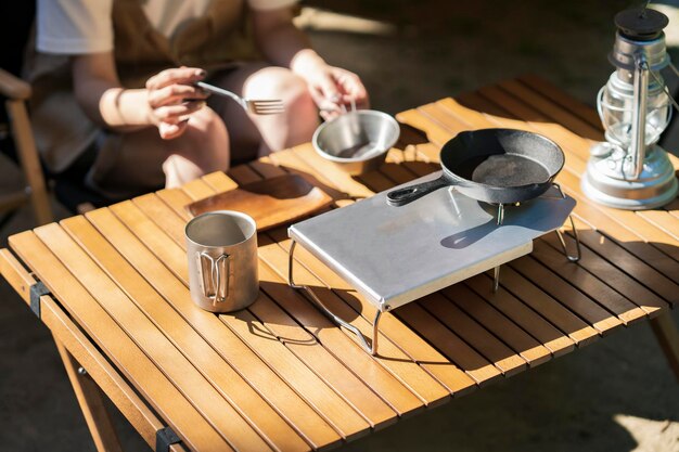 Mesa de comedor en el campamento y mujer joven.