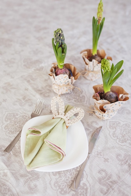 Mesa de comedor festiva de primavera con servilletas de flores y linda decoración de conejito en mantel de lino Tiempo de Pascua Acogedor hogar