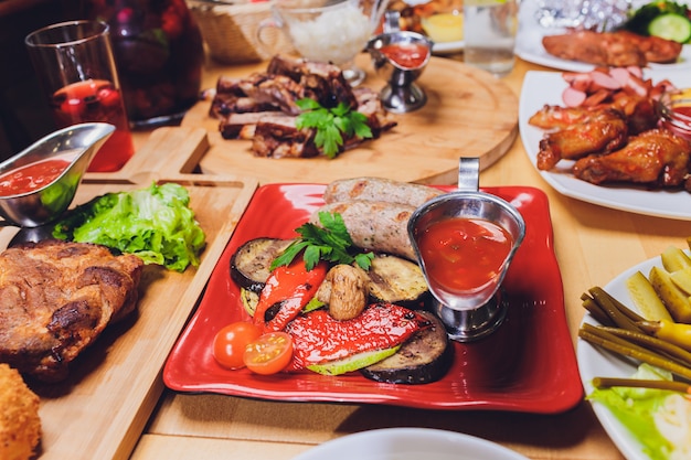 Mesa de comedor con gran variedad de aperitivos y ensaladas. Salmón, aceitunas, vino, verduras, tostadas de pescado a la parrilla. El concepto de una cena de celebración familiar.