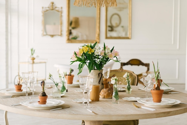 Mesa de comedor con hermosas copas y flores frescas