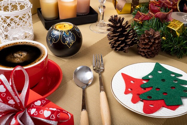 Una mesa de comedor de Navidad con una taza de café roja.