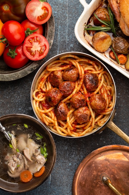 Mesa de comedor con sabrosos platos caseros tradicionales: sopa de pollo, albóndigas con espagueti, pollo asado con patatas. Comida clásica casera natural reconfortante para la cena familiar, vista superior