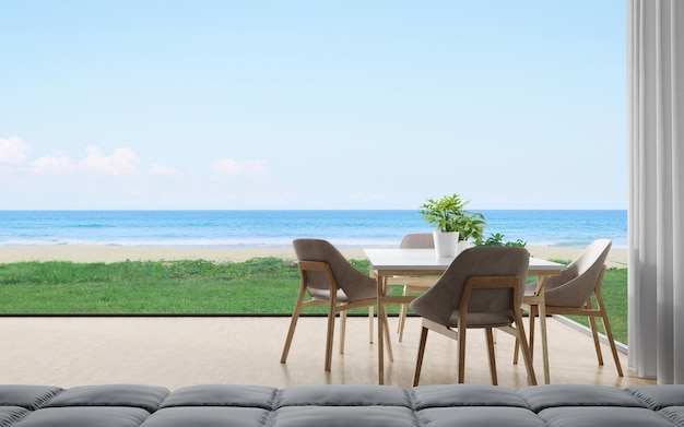 Mesa de comedor con silla y sofá de comedor en casa moderna u hotel de lujo con cielo y mar