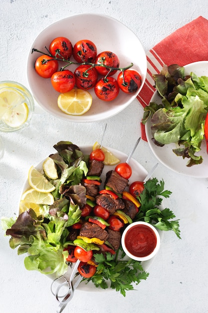 Foto mesa de comida con carne a la parrilla kebab de carne con verduras y salsa vista superior