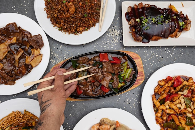 Mesa de comida oriental con varios tipos de comida china