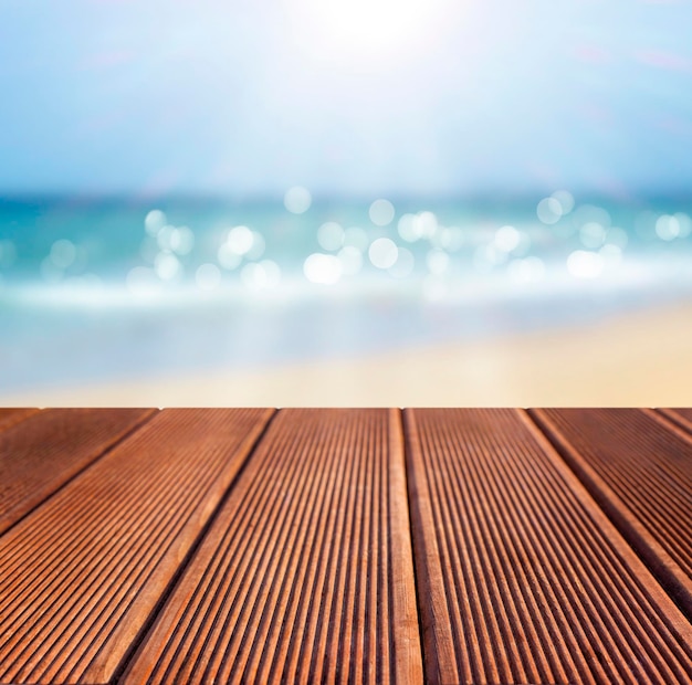 Mesa cubierta de madera sobre fondo borroso de playa tropical y mar
