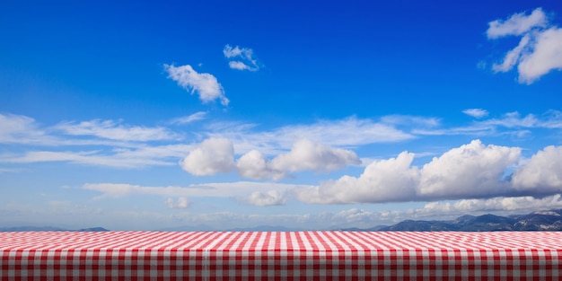 Mesa cubierta con mantel rojo sobre fondo de cielo azul copia espacio ilustración 3d