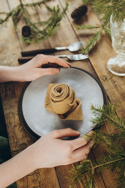 Mesa con cubiertos de cerámica y una servilleta de lino doblada en forma de rosa