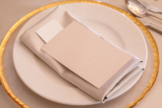 Mesa de cumpleaños de boda festiva con cubiertos dorados y plato de porcelana Maqueta de tarjeta en blanco