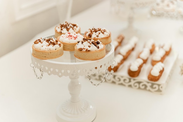 Una mesa con cupcakes y un pastel encima.