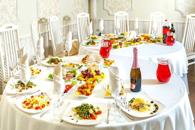 Mesa de banquete posta com petiscos e frutas e champanhe. Foto horizontal