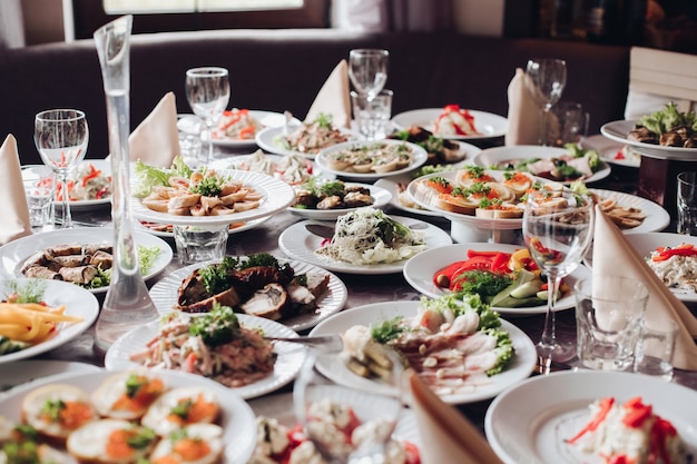 Mesa de banquete servida com vários salgadinhos frios e saladas