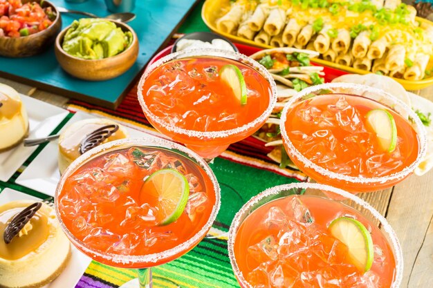 Mesa de bufê de festa Fiesta com margaritas de melancia e outras comidas tradicionais mexicanas.