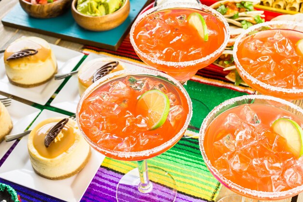 Mesa de bufê de festa Fiesta com margaritas de melancia e outras comidas tradicionais mexicanas.