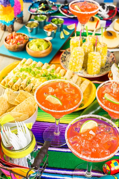 Mesa de bufê de festa Fiesta com margaritas de melancia e outras comidas tradicionais mexicanas.