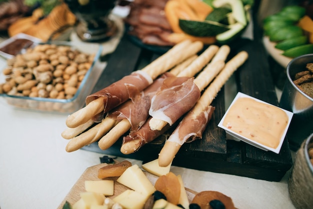 Mesa de bufê de recepção com hambúrgueres salgadinhos frios carne e saladas nozes queijox9