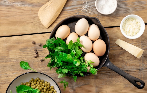 Mesa de café da manhã com ovos crus e ingredientes para a preparação de vista superior de alimentos saudáveis