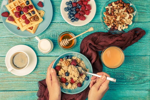 Mesa de café da manhã com waffles, aveia, cereais, café, suco e frutas frescas. café da manhã saudável