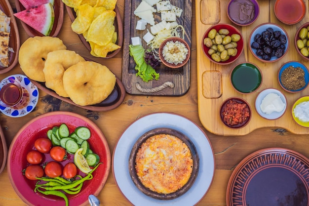 Mesa de café da manhã turco Pastelaria Legumes Verdes Azeitonas Queijos Ovos fritos Especiarias Compotas Mel Chá