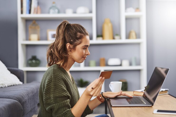 Foto mesa de cartão de crédito e mulher com laptop no chão para transação de assinatura ou compras on-line na sala de estar pagamento doméstico e jovem para serviço de streaming de adesão ou internet banking