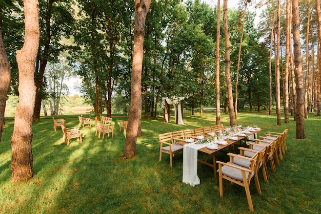 Mesa de casamento com decoração rústica na floresta. celebração de casamento no belo lugar.
