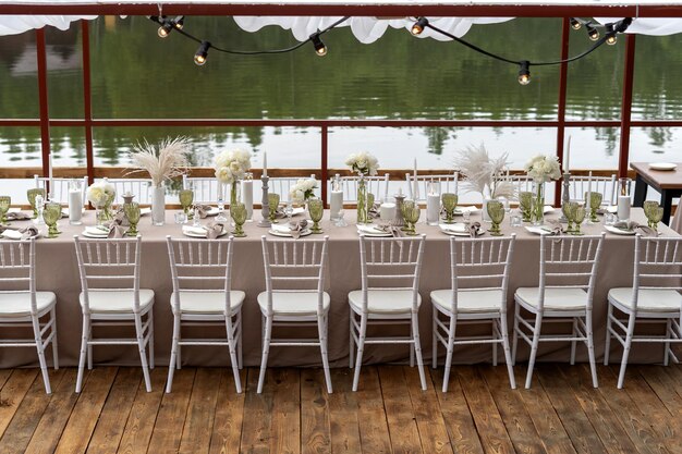 Mesa de casamento decorada, peônias brancas e penas, cadeiras Chiavari estão à mesa